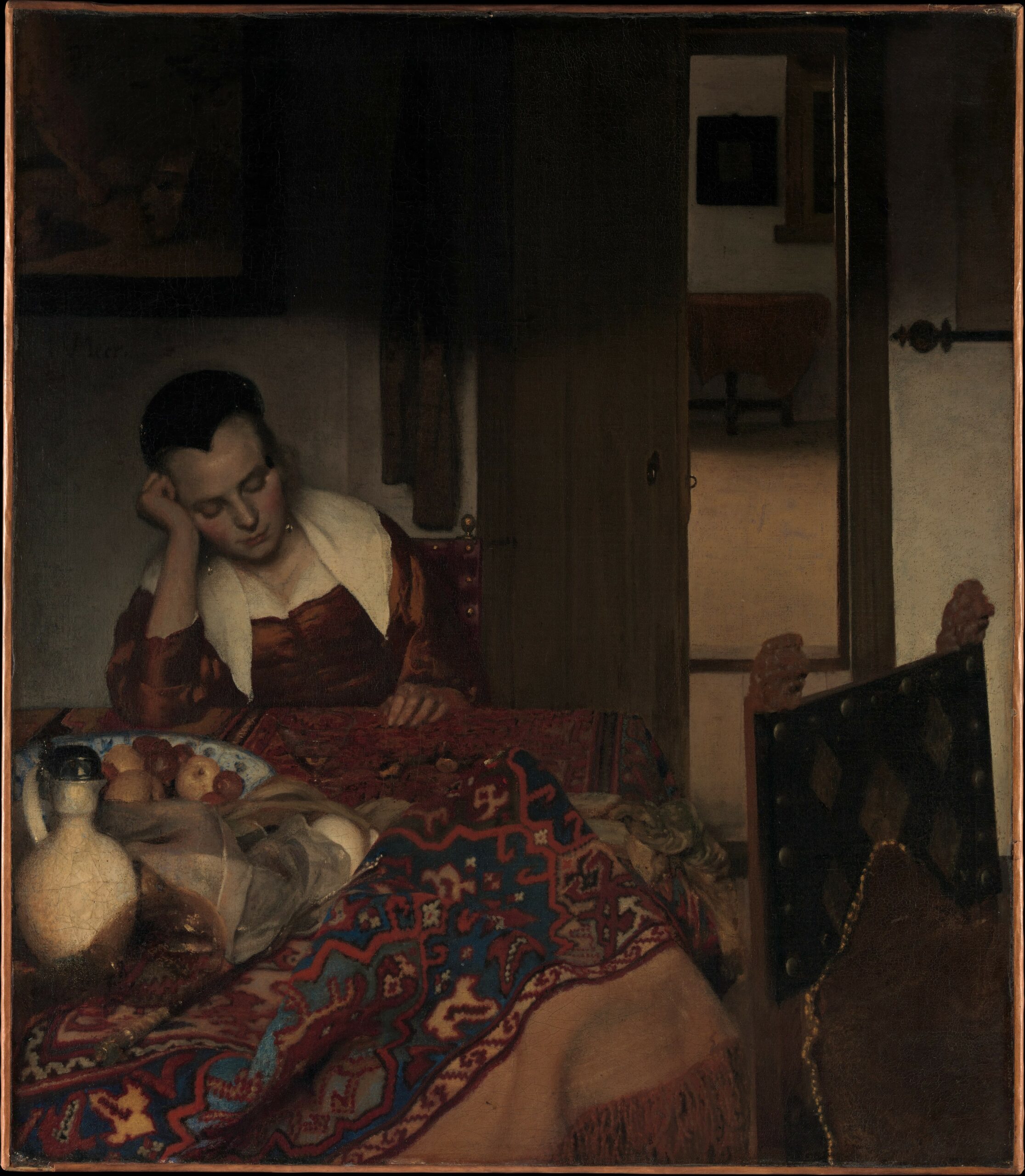 The misbehavior of unsupervised maidservants was a common subject for seventeenth-century Dutch painters. Yet in his depiction of a young maid dozing next to a glass of wine, Vermeer transfigured an ordinary scene into an investigation of light, color, and texture that supersedes any moralizing lesson. While the toppled glass at left (now abraded with time) and rumpled table carpet may indicate a recently departed visitor, X-radiographs indicate that Vermeer chose to remove a male figure he had originally included standing in the door­way, heightening the painting’s ambiguity.