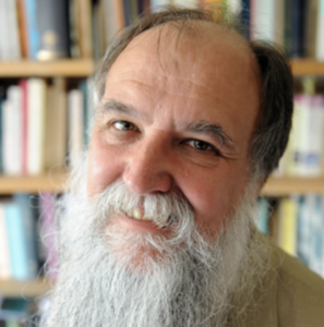 Photograph of Peter Mack in front of a bookshelf